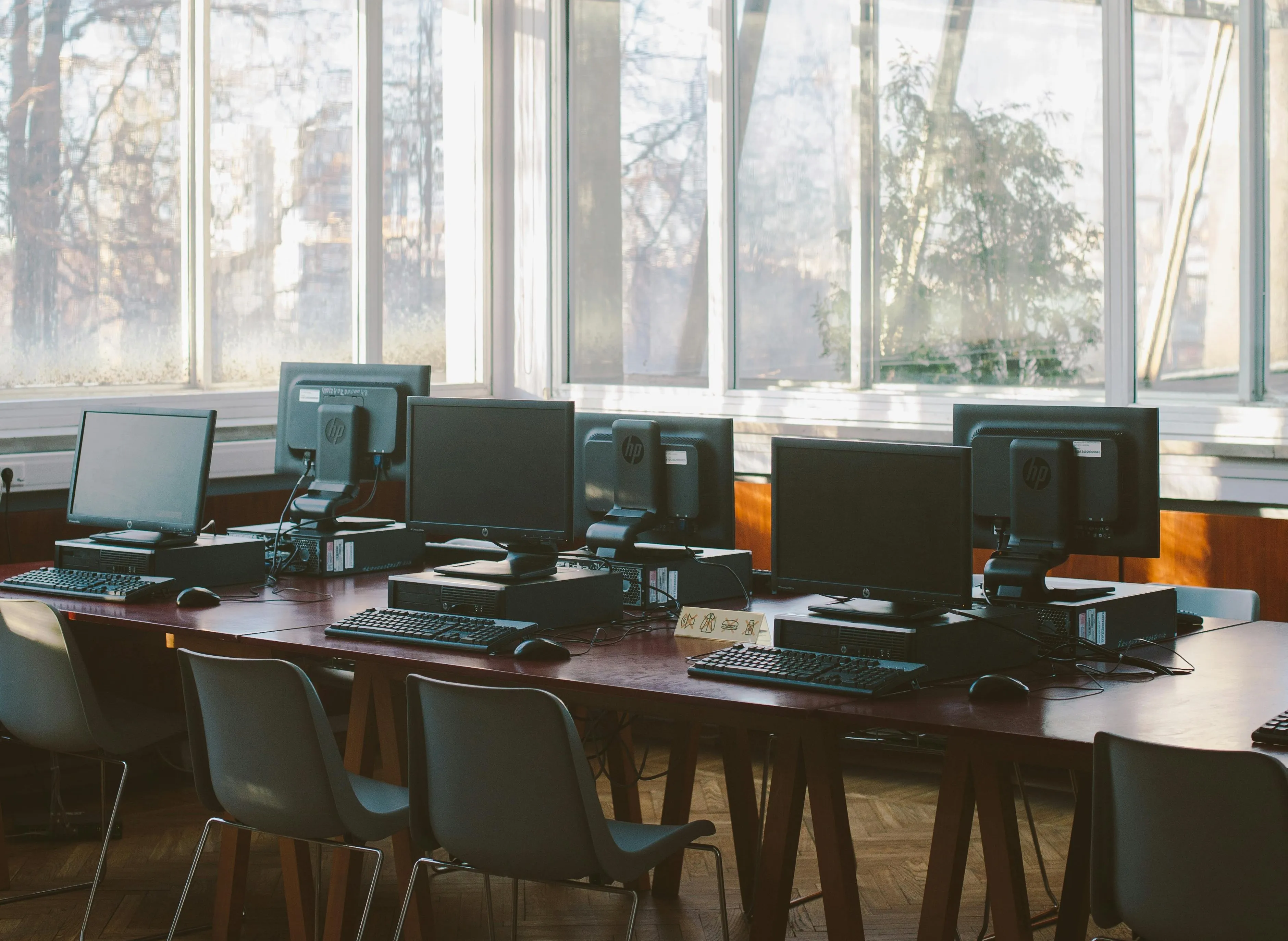 Modern HP computer lab with multiple desktop workstations near sunny window.
