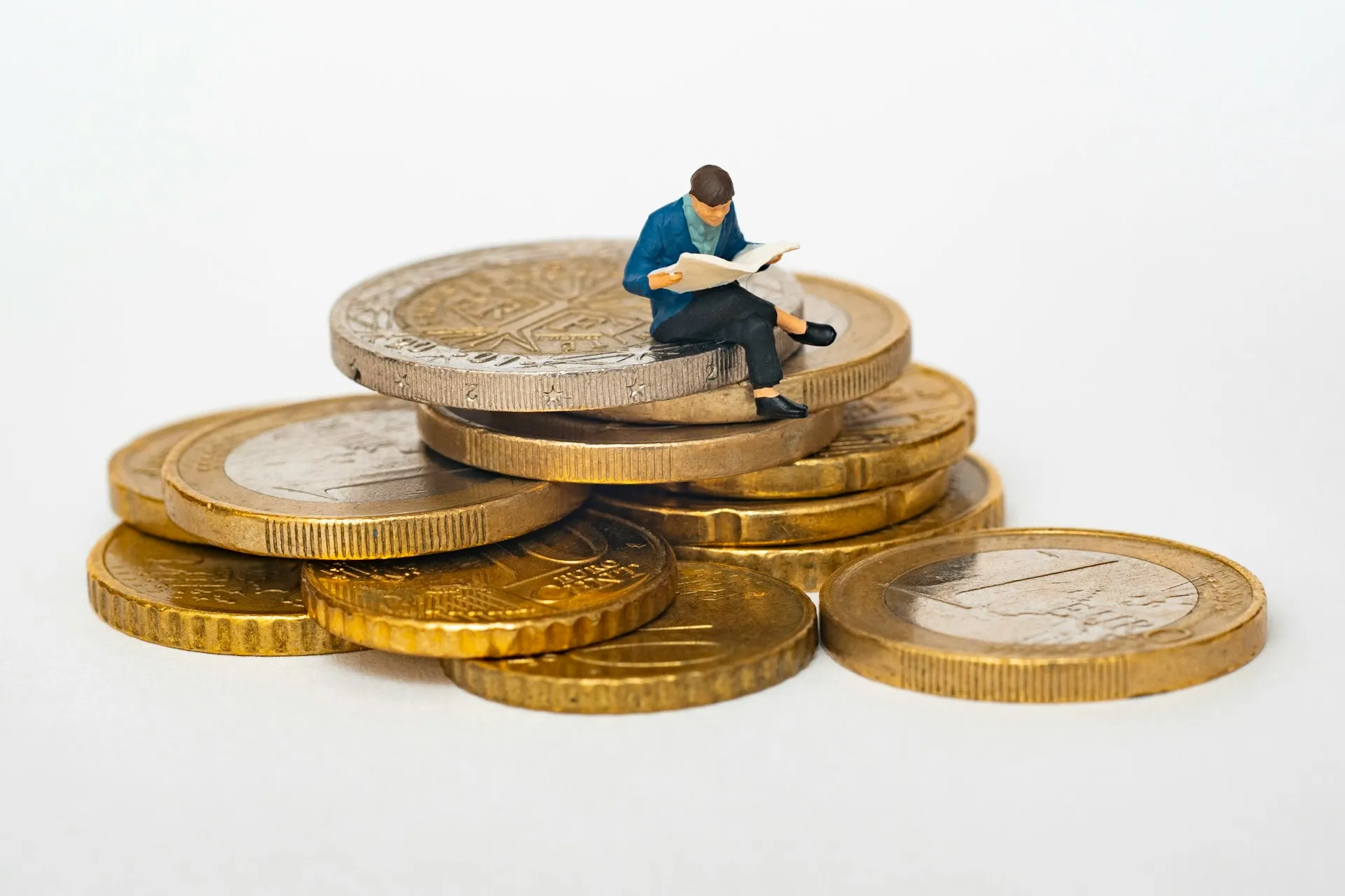 Man reading newspaper sitting on stacked coins pile