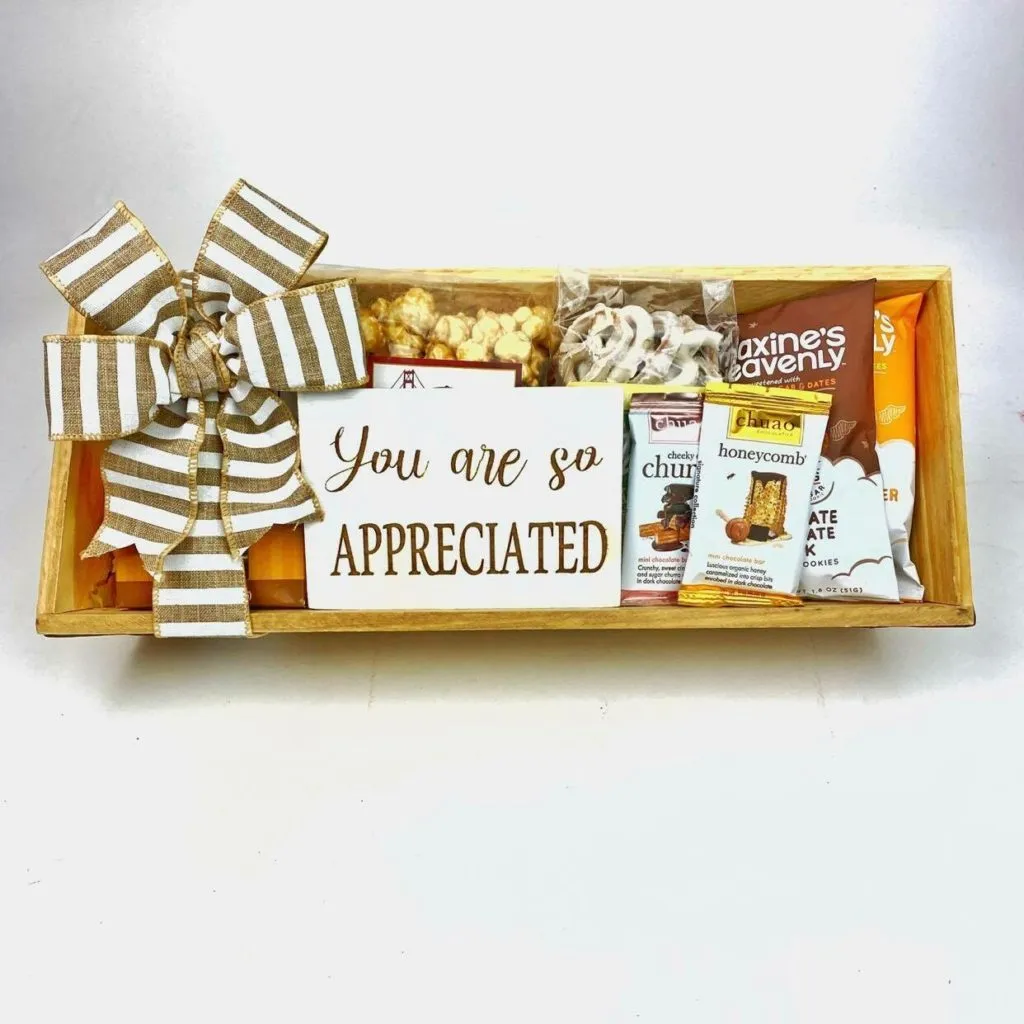 Gourmet snack gift basket with popcorn, chocolate, cookies, and appreciation sign.